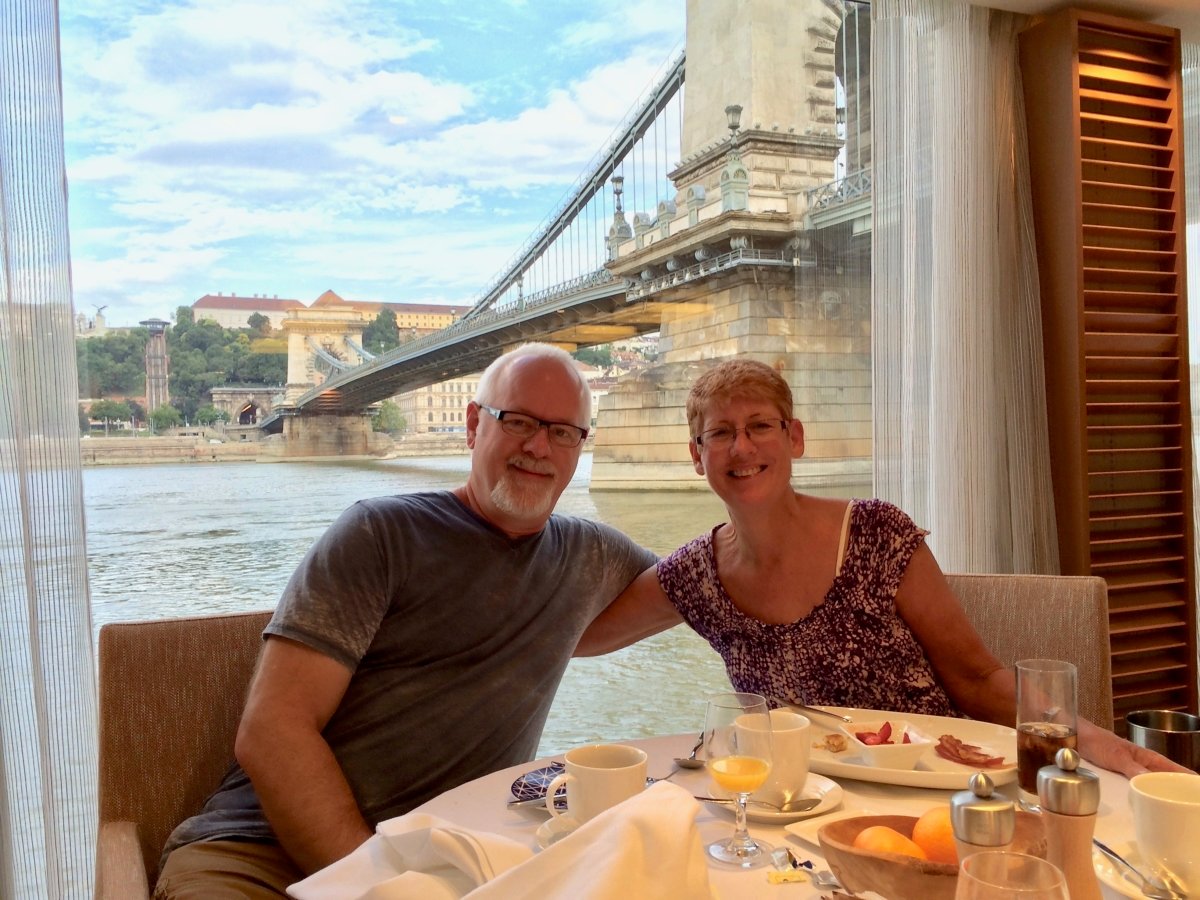 Howard and Kathy on Viking river cruise ship with the Budapest Chain Bridge in the background.