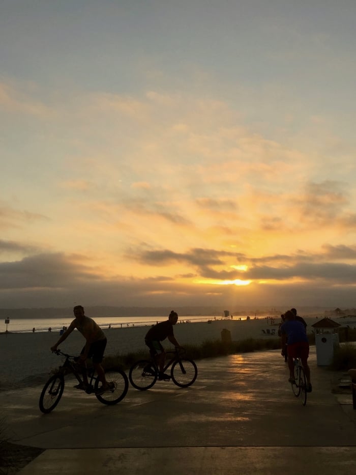 People riding bicycles at sunset